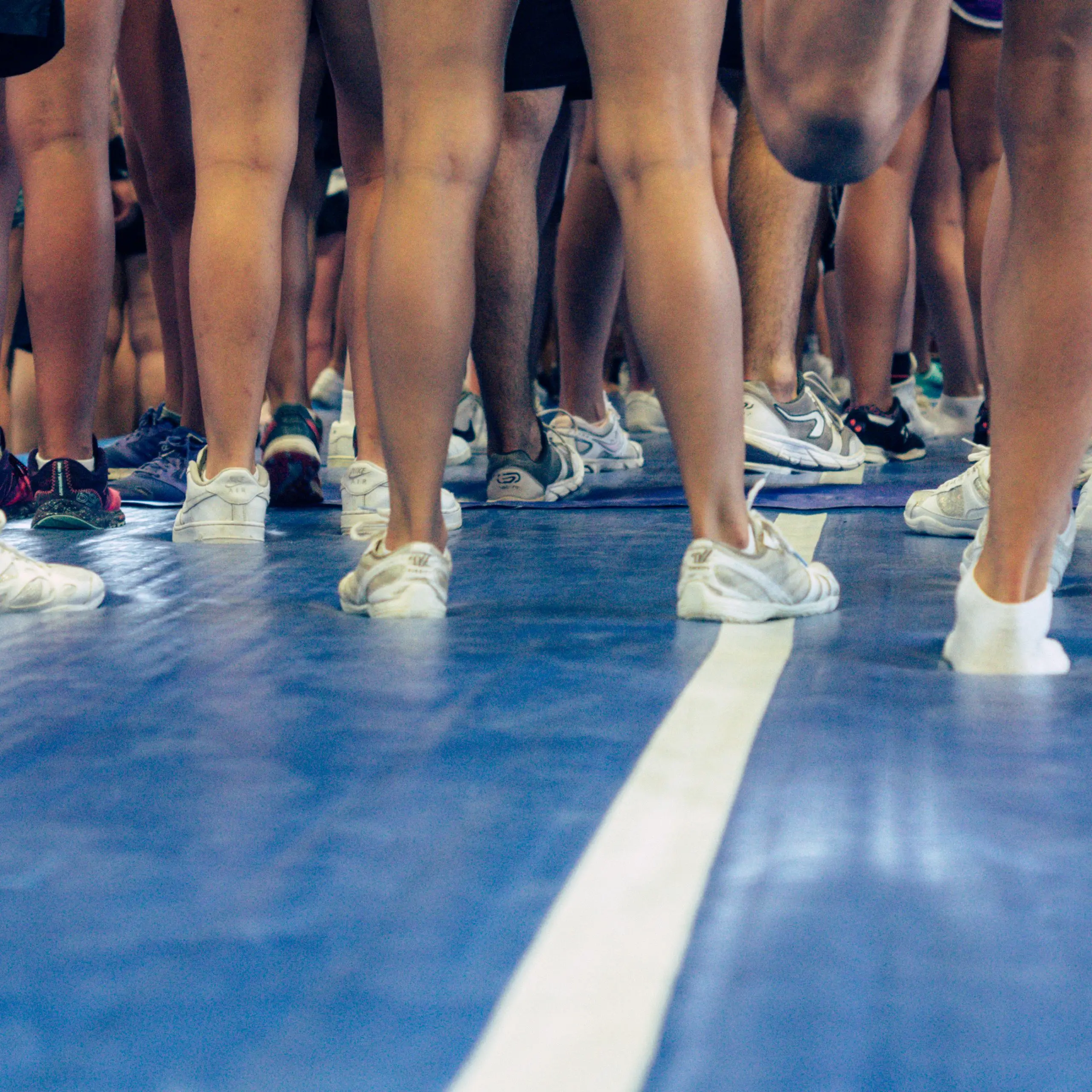 Feet of cheerleaders on a inflatable blue mat