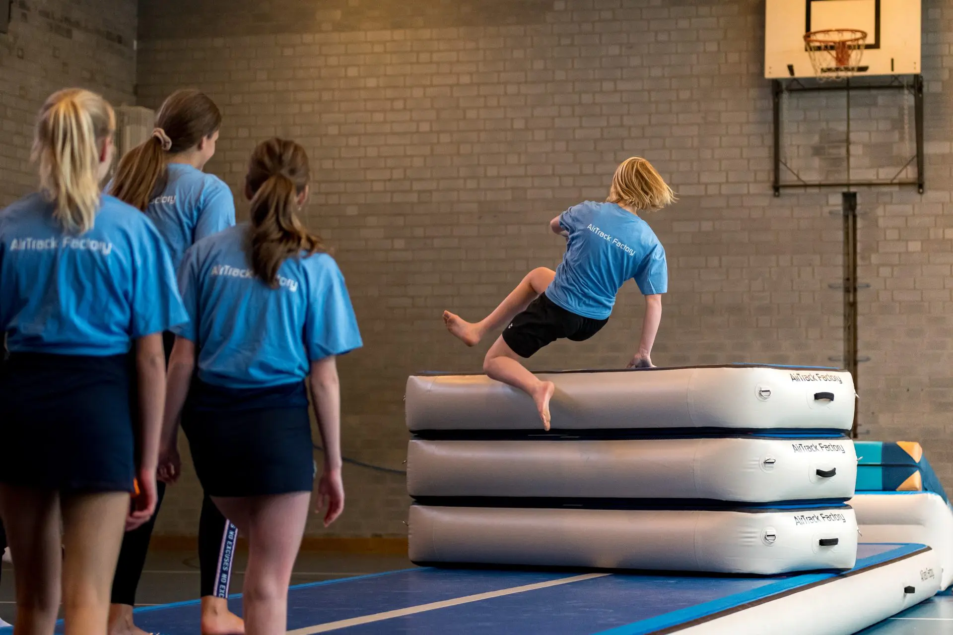 Girl jumping over Aand inflatable vaulting table in school