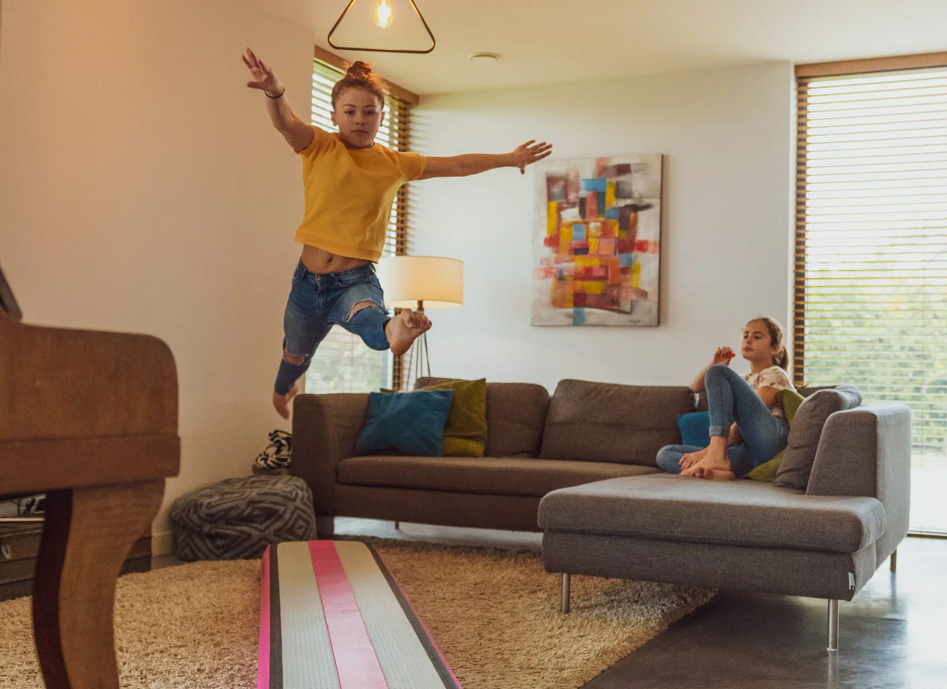 Girl leaping on pink AirBeam in livingroom