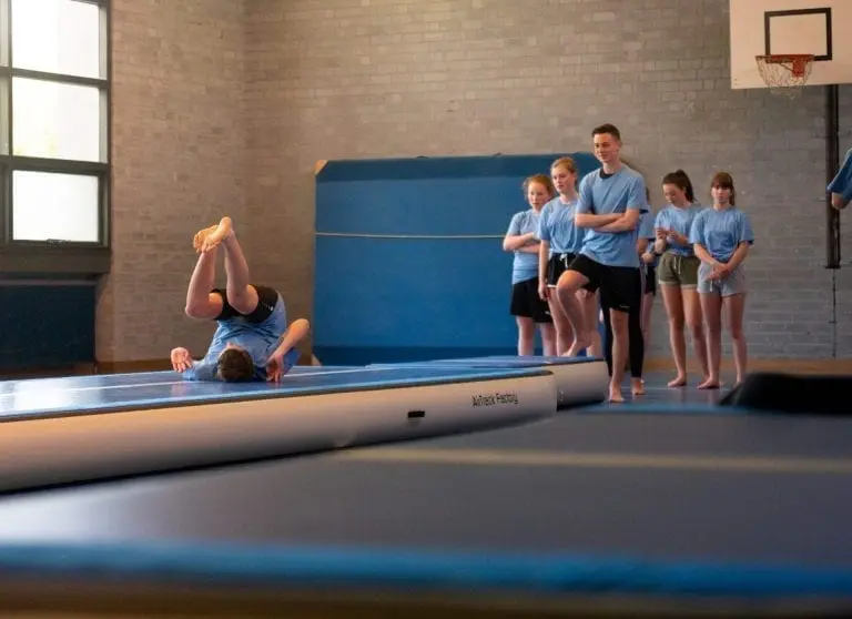 girl practising head roll on airtrack p3 in school